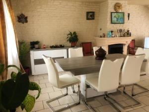 a dining room with a table and white chairs at Villa de 4 chambres avec piscine privee jardin clos et wifi a Saint Martin Longueau in Saint-Martin-Longueau