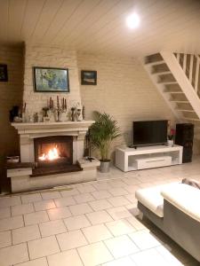 a living room with a fireplace and a tv at Villa de 4 chambres avec piscine privee jardin clos et wifi a Saint Martin Longueau in Saint-Martin-Longueau