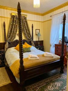 Rosebank House Bed & Breakfast في ستراثير: غرفة نوم عليها سرير وفوط