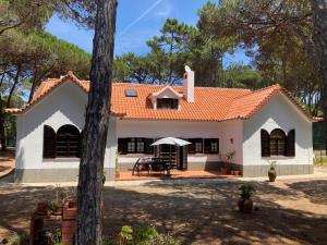 a small white house with an orange roof at Moradia no Pinhal com Piscina - Espaço e Privacidade para as suas Férias! in Sintra