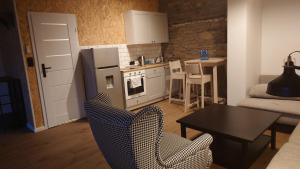 a kitchen with a refrigerator and a table and chairs at Apartamenty STONEHENGE in Sosnowiec