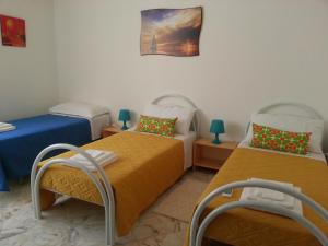 a room with two beds and a chair in it at La Via del Mare - Acireale Centro storico in Acireale