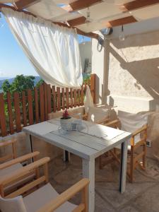 a white table and chairs on a patio at Villa Rena Agios Petros in Áyios Pétros