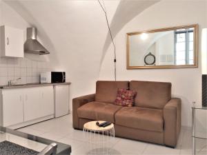 uma sala de estar com um sofá e uma mesa em "Sous les Voûtes" -Garage privé optionnel -Centre historique-Plages à 21km ! em Pézenas