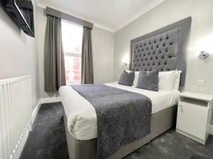 ein Hotelzimmer mit einem großen Bett und einem Fenster in der Unterkunft Park House Hotel in Blackpool