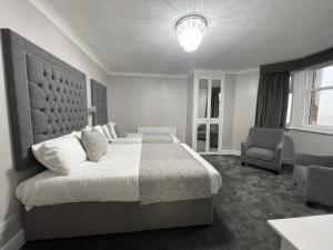 a bedroom with a large bed and a chair at Park House Hotel in Blackpool