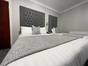 a bedroom with two beds with white sheets and pillows at Park House Hotel in Blackpool