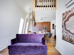 a purple couch in a living room with a table at Residentas Sao Pedro in Lisbon