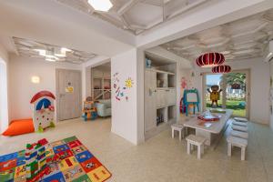 Habitación infantil con mesa, sillas y zona de juegos. en D - Resort Ayvalık, en Ayvalık
