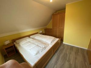 a bedroom with a large bed with white sheets at Ferienwohnung-Leichtwind in Lemkenhafen auf Fehmarn