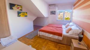 a small bedroom with a bed and a window at Mila Apartments in Mostar