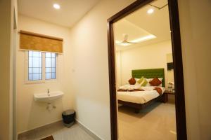 a bathroom with a bed and a sink and a mirror at SAARA INN in Pondicherry
