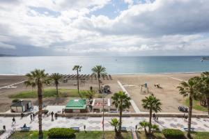 a view of a beach with palm trees and the ocean at iloftmalaga Malagueta Premium in Málaga