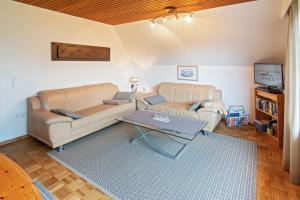 ein Wohnzimmer mit zwei Sofas und einem Tisch in der Unterkunft Ferienhaus Seestern in Dornumersiel