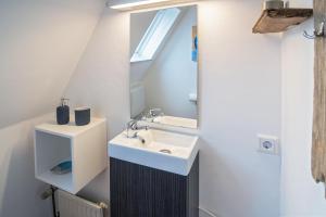 ein Badezimmer mit Waschbecken und Spiegel in der Unterkunft Ferienhaus Seestern in Dornumersiel + 22 Fotos