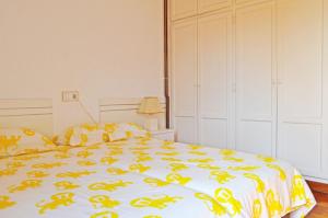 a bedroom with a bed with a yellow and white blanket at Apartamento El Corro: con parking en pleno centro de Comillas in Comillas