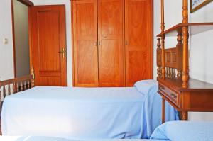 ein Schlafzimmer mit einem Bett, einer Kommode und einem Etagenbett in der Unterkunft Apartamento El Corro: con parking en pleno centro de Comillas in Comillas