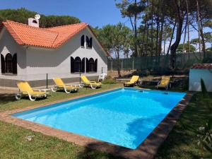 a swimming pool in front of a house at Moradia no Pinhal com Piscina - Espaço e Privacidade para as suas Férias! in Sintra