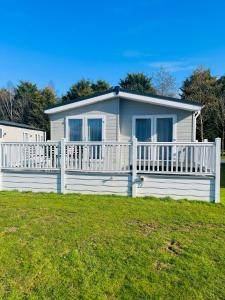 a white house with a white fence in the grass at Hemingway Lodge with Hot Tub in York
