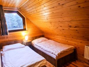um quarto com 2 camas num chalé de madeira em Domki nad Wartą em Prusicko