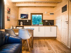 a kitchen with a couch and a table in a room at Domki nad Wartą Kajaki & SPA in Prusicko