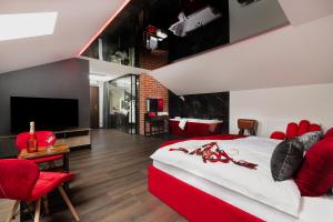 a bedroom with a large bed and red chairs at Hotel Korona Spa & Wellness in Lublin