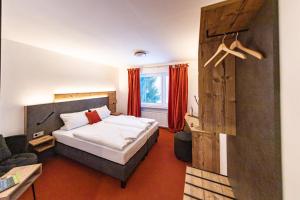 ein Hotelzimmer mit einem Bett und einem Stuhl in der Unterkunft Am Ochsenkopf in Bischofsgrün