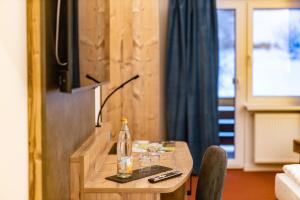 a room with a table with a bottle and a television at Am Ochsenkopf in Bischofsgrün