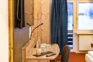 Zimmer mit einem Tisch mit einer Flasche und einem TV in der Unterkunft Am Ochsenkopf in Bischofsgrün