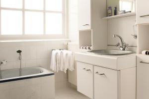 een witte badkamer met een wastafel en een bad bij Het Jaarsveldhof in Montfoort