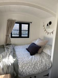 a bedroom with a bed and a window at Peaceful Shepherd’s Hut in beautiful countryside. in Linlithgow