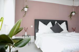 1 dormitorio con cama blanca y pared rosa en Freien Living Angerberg, en Angerberg