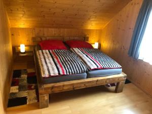 a bed in a room with a wooden wall at St Wolfgang-Kienberg - Ruhe und Entspannung mit bester Aussicht in Obdach
