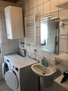 a bathroom with a sink and a washing machine at St Wolfgang-Kienberg - Ruhe und Entspannung mit bester Aussicht in Obdach