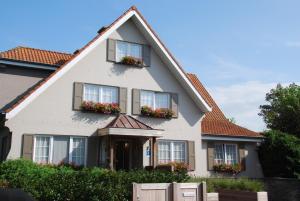 a house with flower boxes on the windows at Hotel Rubens in De Haan