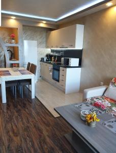 kuchnia oraz salon ze stołem i kanapą w obiekcie Sunshine Apartment w mieście Pomorie