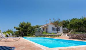 a villa with a swimming pool and a house at Akritas in Koroni