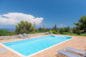 a swimming pool with two lawn chairs and a swimming pool at Akritas in Koroni