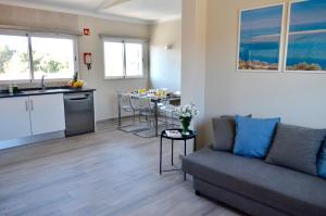 uma sala de estar com um sofá e uma cozinha em Villa ELTAEL - Rita Apartment - Piscina Aquecida e Partilhada na Manta Rota