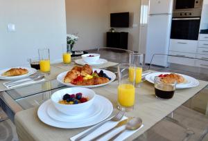 uma mesa com pratos de comida e taças de fruta em Villa ELTAEL - Rita Apartment - Piscina Aquecida e Partilhada em Manta Rota
