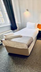 a bed in a room with white sheets and pillows at Sneyd Arms Hotel Tunstall in Chatterley +6 photos