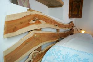 a wooden headboard of a bed in a room at Le Case di Mara - Appartamenti Tipici "Stazzo Giovannareddu" in Porto San Paolo
