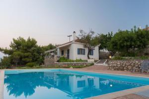 a villa with a swimming pool in front of a house at Akritas in Koroni