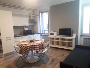 a living room with a table and a kitchen with a table and chairs at Antichi Sapori Apartment One in Bellagio