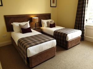 a hotel room with two beds and a window at Cameron Club Lodges in Balloch