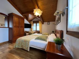 um quarto com uma cama grande e um tecto em madeira em Hostal Rural Salazar em Oronz