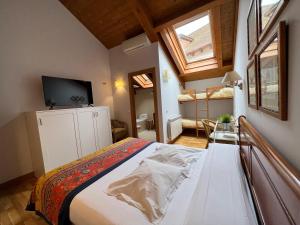 um quarto com uma cama e uma televisão num quarto em Hostal Rural Salazar em Oronz