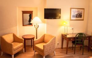 a hotel room with a table and two chairs and a desk at Landhotel Groggerhof in Obdach