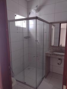 a glass shower in a bathroom with a sink at Hotel Sabrina in Guanambi