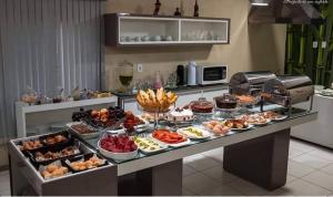 un buffet con muchos tipos diferentes de comida en una mesa en Hotel Sabrina en Guanambi
